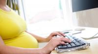 pregnant woman typing at a computer